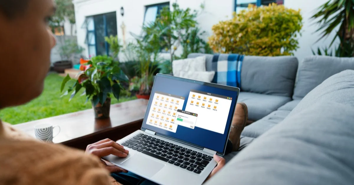 A man working remotely on a laptop outdoors, viewing digital folders